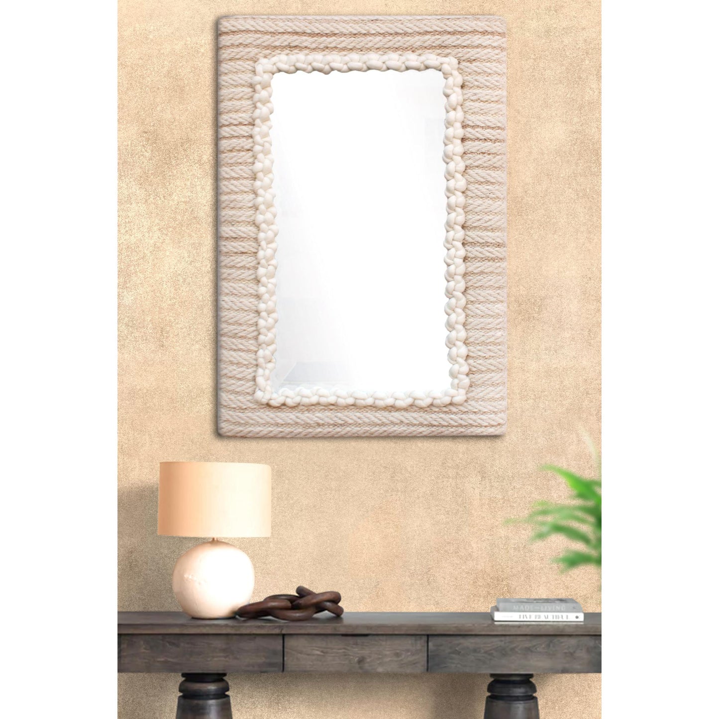 Decorative mirror with a textured frame on a beige wall above a wooden console table.