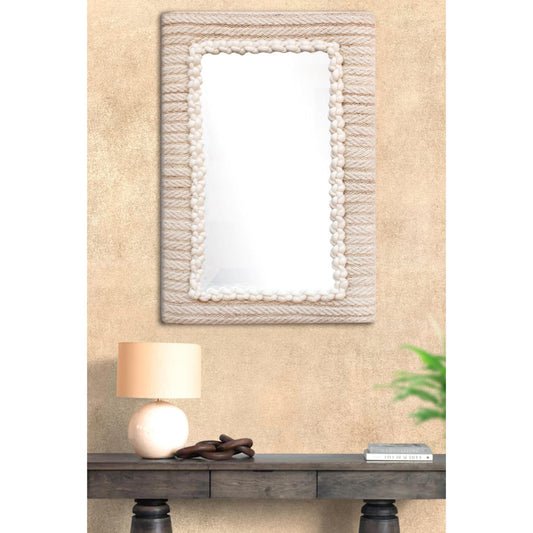 Decorative mirror with a textured frame on a beige wall above a wooden console table.